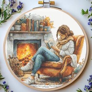 May include: A woman sits in a cozy armchair by a fireplace, reading a book. She is wearing a white sweater and a brown scarf. The fireplace is lit and there are logs burning inside. The room is decorated with a bookshelf and a vase of flowers.