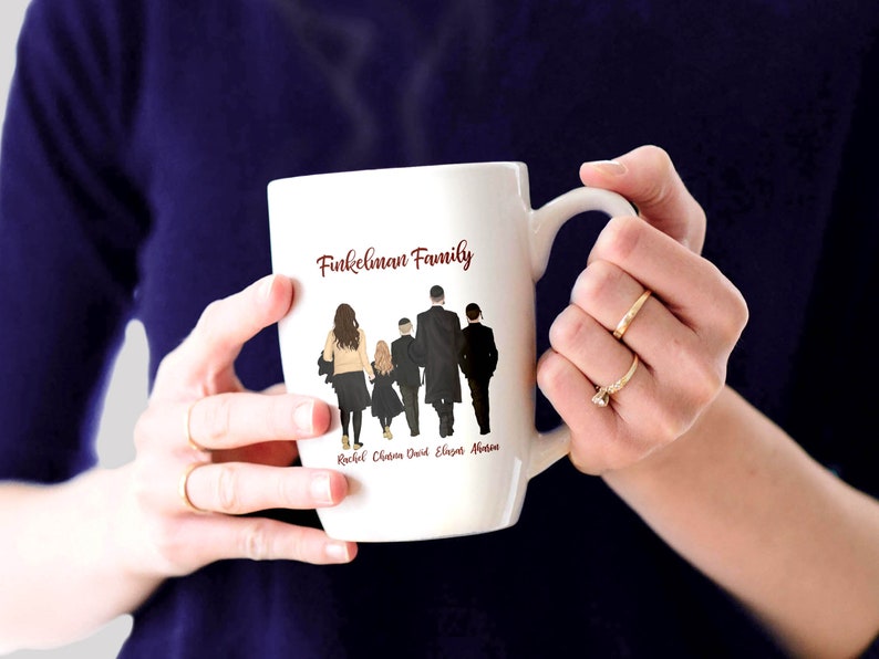 Może przedstawiać: Biały kubek ceramiczny z czerwonym napisem "Finkelman Family" i sylwetką pięcioosobowej rodziny idącej. Pod sylwetkami widnieją imiona Rachel, Chloe, David, Eliana i Ava.