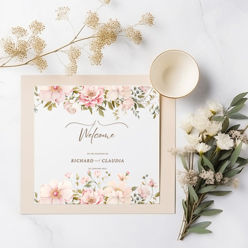 May include: A wedding welcome sign with a floral design in shades of pink and green. The sign says "Welcome to the wedding of Richard and Claudia, 21 January 2023".