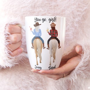 May include: White ceramic mug with a design of two women riding horses. The text "You go, girl!" is printed on the mug. The names "Jenny" and "Sarah" are printed below the women.