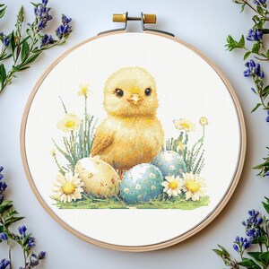 May include: A yellow chick sits on a bed of green grass and flowers, surrounded by colorful Easter eggs.