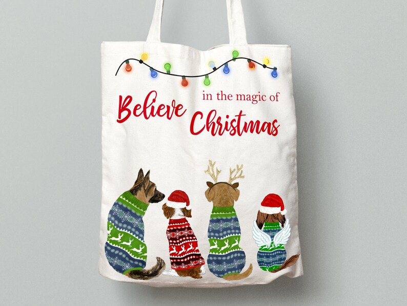 May include: White canvas tote bag with the text "Believe in the magic of Christmas" and a string of Christmas lights. Four dogs wearing Christmas sweaters are sitting in a row at the bottom of the bag.