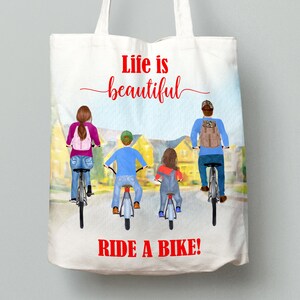 May include: White tote bag with a colorful illustration of a family riding bikes. The text "Life is beautiful" and "RIDE A BIKE!" are in red. The bag has a light blue and yellow background.