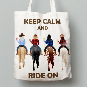 May include: A white tote bag with brown text that reads "Keep Calm and Ride On". Four women are riding horses in the background. The women are wearing cowboy hats and plaid shirts.