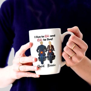Pu&ograve; includere: Una tazza in ceramica bianca con un'illustrazione in bianco e nero di una coppia in moto. Il testo "I live to Ride and Ride to live!" &egrave; stampato sulla tazza. I nomi "David" e "Bonnie" sono stampati sotto l'illustrazione.
