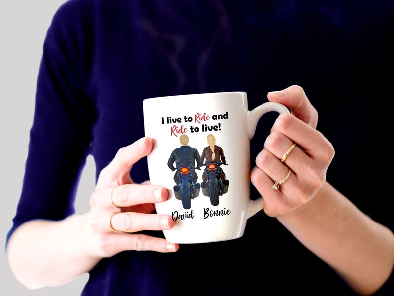 Pu&ograve; includere: Una tazza in ceramica bianca con un'illustrazione in bianco e nero di una coppia in moto. Il testo "I live to Ride and Ride to live!" &egrave; stampato sulla tazza. I nomi "David" e "Bonnie" sono stampati sotto l'illustrazione.