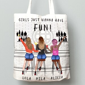 Peut inclure: Sac fourre-tout blanc avec une illustration en noir et blanc de trois femmes assises &agrave; un bar avec des boissons. Le texte "Girls Just Wanna Have Fun!" est imprim&eacute; sur le sac. Les noms "Lola", "Mila" et "Alicia" sont imprim&eacute;s sous les femmes.