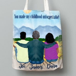 May include: A white tote bag featuring a watercolour illustration of three people seated on a wooden jetty. The individuals are facing away from the viewer with their arms around each other. The backdrop is a blue sky with white clouds and green mountains. The text "You made my childhood unforgettable!" is printed on the bag. The names "Joe", "James", and "Daisa" are printed beneath the figures.