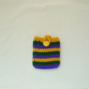 May include: A purple, green, and gold striped crocheted phone case with a yellow button.