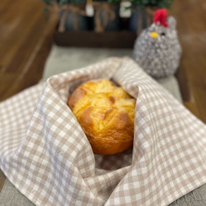 May include: A loaf of bread wrapped in a brown and white checkered cloth. The cloth has the words "Love You Big Handmade" printed on it.
