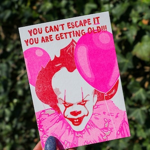 Pennywise riso imprime cartão de aniversário engraçado de palhaço de terror envelhecido. Cartão para Ventilador de Filme de Terror IT Cores neon vibrantes feitas com máquina de riso.