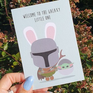 Postkarte Willkommen in der Galaxie Mandalorianer und Baby Yoda. Diese neue Baby Jedi Karte ist Star Wars Inspiriert, Willkommen Baby Yoda in der Galaxie.