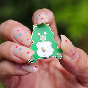 Szpilka emaliowana Good Luck Care Bear z czterolistną koniczyną to świetny prezent w postaci zabawek retro dla miłośników lat 90. lub urocza spinka do klapy z misiem na Dzień Świętego Patryka