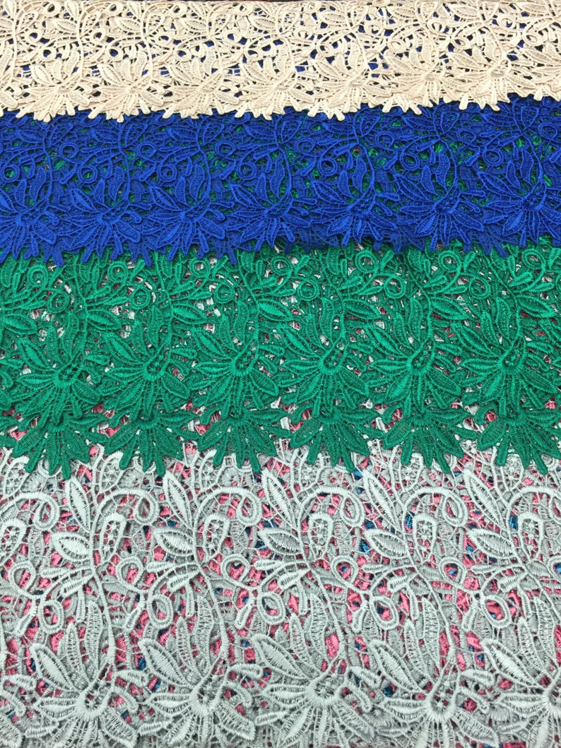 May include: Four different lace trims in beige, blue, green, and gray. The lace trims have a floral pattern.