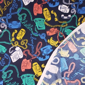 May include: A dark blue fabric with a repeating pattern of vintage rotary phones, colorful cords, and the words "Hello" and "Bonjour".