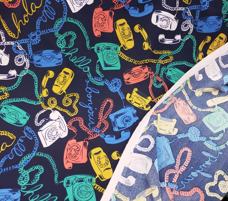 May include: A dark blue fabric with a repeating pattern of vintage rotary phones, colorful cords, and the words "Hello" and "Bonjour".