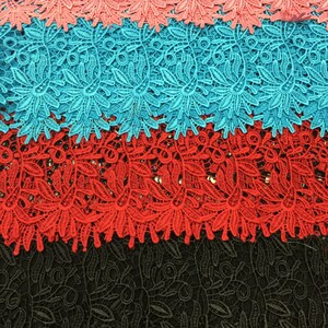 May include: Four layers of lace fabric in different colors. The top layer is a light pink, the second layer is a turquoise blue, the third layer is a bright red, and the bottom layer is black.