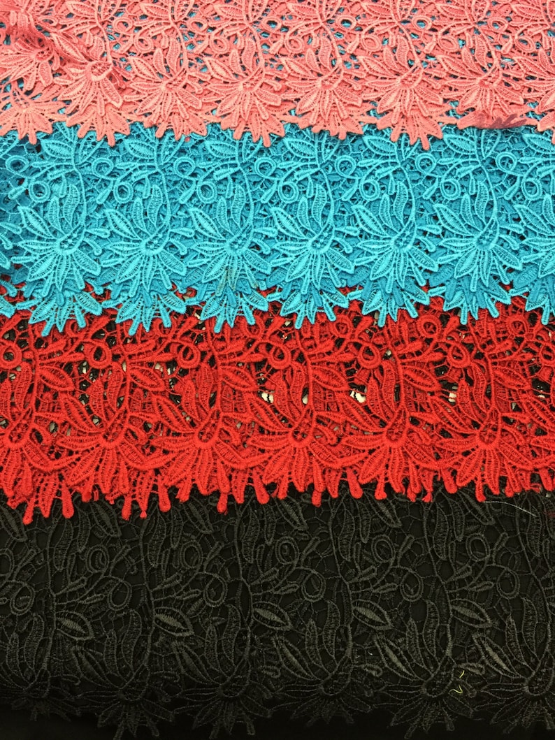 May include: Four layers of lace fabric in different colors. The top layer is a light pink, the second layer is a turquoise blue, the third layer is a bright red, and the bottom layer is black.