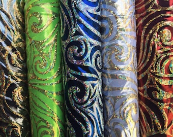 May include: Four rolls of fabric with a gold and iridescent swirl pattern. The fabric rolls are red, blue, silver, and green.