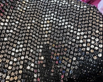 Peut inclure: Gros plan sur un tissu noir avec des paillettes argentées disposées en motif répétitif.