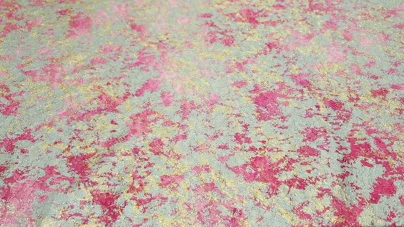 May include: A textured background with a mix of silver, pink, and gold colors. The background has a speckled appearance.