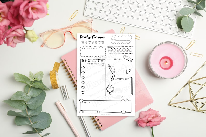 Puede incluir: Un planificador diario en blanco y negro con secciones para objetivos, listas de tareas y citas. El planificador est&aacute; sobre un cuaderno rosa, rodeado de art&iacute;culos de papeler&iacute;a, una vela y flores. El texto "Daily Planner" es visible.