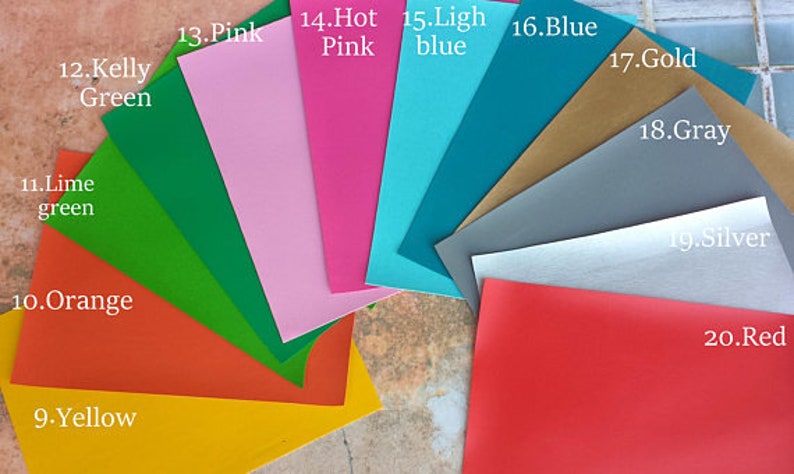 May include: A fan of colorful paper sheets in various shades, including yellow, orange, lime green, Kelly green, pink, hot pink, light blue, blue, gold, gray, silver, and red. Each sheet is labeled with its color name.