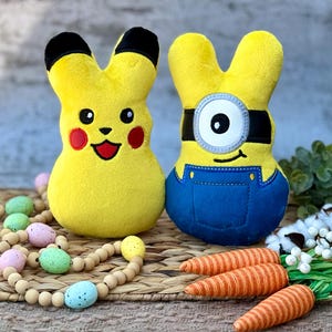 May include: Two plush Easter bunny toys, one yellow with a Pikachu face and the other yellow with a Minion face. The toys are sitting on a woven mat with a wooden bead garland and carrots.