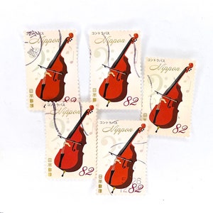 May include: Five vintage Japanese postage stamps featuring a double bass with the text "Nippon Kontrabass" and the number "82" on each stamp.