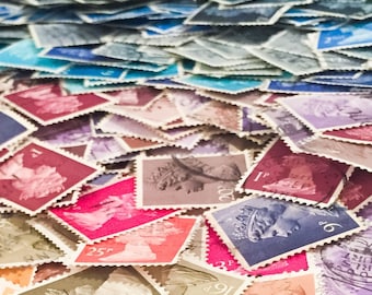 May include: A large pile of colorful postage stamps featuring various designs and denominations. The stamps are arranged in a random pattern, creating a visually appealing and textured background.