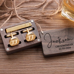 May include: A wooden box with a gold tie clip and cufflinks. The box is engraved with the name "Jackson" and the words "Groomsman 02-05-2024".