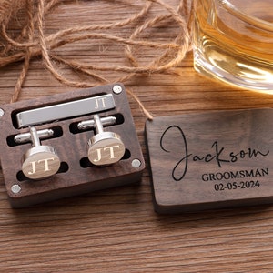 Puede incluir: Una caja de madera con un clip para corbata y gemelos grabados con las iniciales "JT". Una placa de madera separada est&aacute; grabada con el nombre "Jackson", la palabra "Groomsman" y la fecha "02-05-2024".