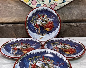 May include: Set of four blue and red Christmas dinner plates featuring a Santa Claus illustration with a red and white robe, carrying a wreath and a sack. The plates have a red rim.