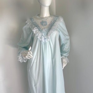 May include: A light blue nightgown with a lace trim and a floral design. The nightgown has long sleeves and a V-neckline.