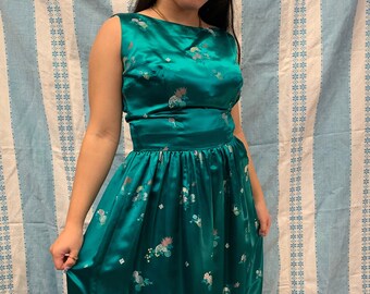May include: A teal blue satin dress with a floral pattern. The dress has a sleeveless bodice and a full skirt.