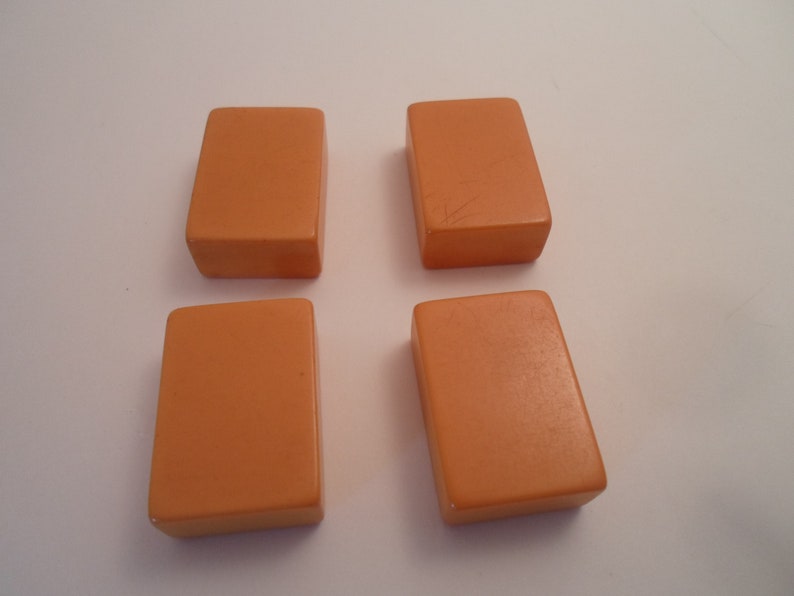 May include: Four rectangular orange tiles, each with a smooth surface.