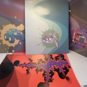 May include: Three colorful folders with different designs. The first folder has a green monster truck on a brown and yellow background. The second folder has a black motorcycle on a blue and green background. The third folder has a red semi-truck on a purple and brown background.