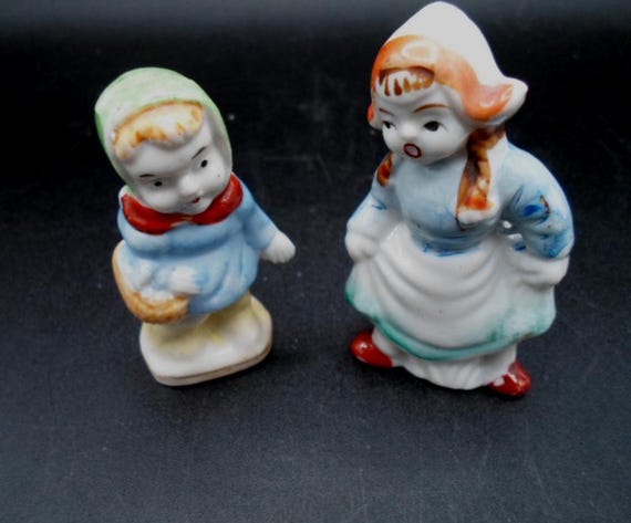 2 Japan Ceramic figures Baby holding Egg Basket Easter Dutch Bonnet Girl Both Marked Japan