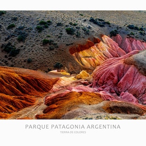 May include: A panoramic view of colourful rock formations in Parque Patagonia Argentina, Tierra de Colores. The landscape features a variety of shades of red, orange, yellow, and grey.