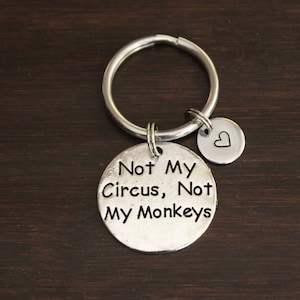 May include: Silver keychain with a round charm that says "Not My Circus, Not My Monkeys" and a smaller heart charm.