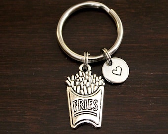 May include: Silver keychain with a charm of a french fry container with the word "FRIES" on it and a small heart charm.