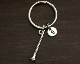 May include: Silver keychain with a small trumpet charm and a round charm with the letter E.