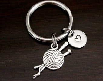 May include: Silver keychain with a yarn ball and knitting needles charm, a heart charm, and a silver key ring.