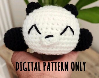 May include: A handmade crochet panda with a white head and black ears and arms. The panda has a smiling face with black embroidered details. The text "DIGITAL PATTERN ONLY" is displayed below the panda.