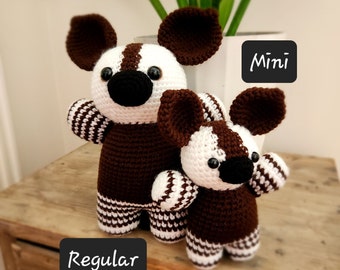 May include: Two crocheted stuffed animals, one brown and white striped and one smaller brown and white striped, with the words "Regular" and "Mini" written on the surface below them.