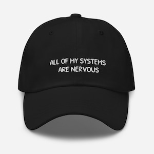 Pode incluir: Boné de beisebol preto com texto bordado em branco que diz "All of my systems are nervous".