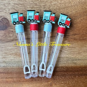 May include: Four clear plastic bubble wands featuring a train-shaped topper. Each topper is light blue and red with black wheels. The wands have a red screw-on cap and a white internal wand with a loop. The text Nonna's Little Treasure is visible.
