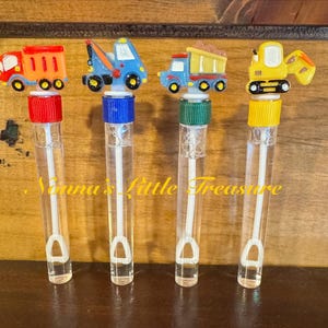 May include: Four clear plastic bubble wands with different colored tops and toy vehicle toppers. The toppers are a red dump truck, a blue tow truck, a yellow dump truck, and a yellow excavator.