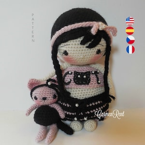 May include: Crocheted doll with black hair, pink headband, and a pink and white "CUT" shirt. The doll is holding a crocheted black and pink cat.