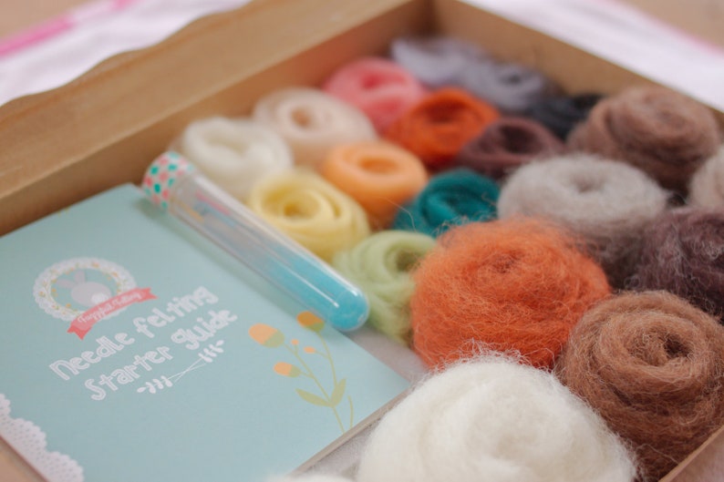 May include: A needle felting starter kit with a variety of colored wool fibers, a needle felting tool, and a guide booklet with the text "Needle felting starter guide".